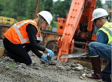 Environmental assessment and compliance - two people in hard hats working outside