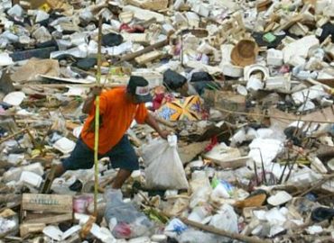 Landfill insurance claim support - man picking up trash in a landffill