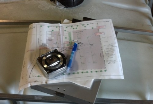 Site plan for permitting and compliance with tape measure on top of a notebook.