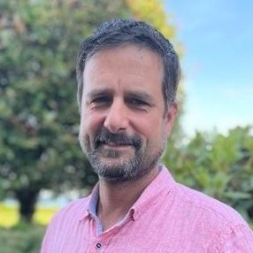 smiling-farallon-employee-with-a-beard-wearing-a-pink-collared-shirt-